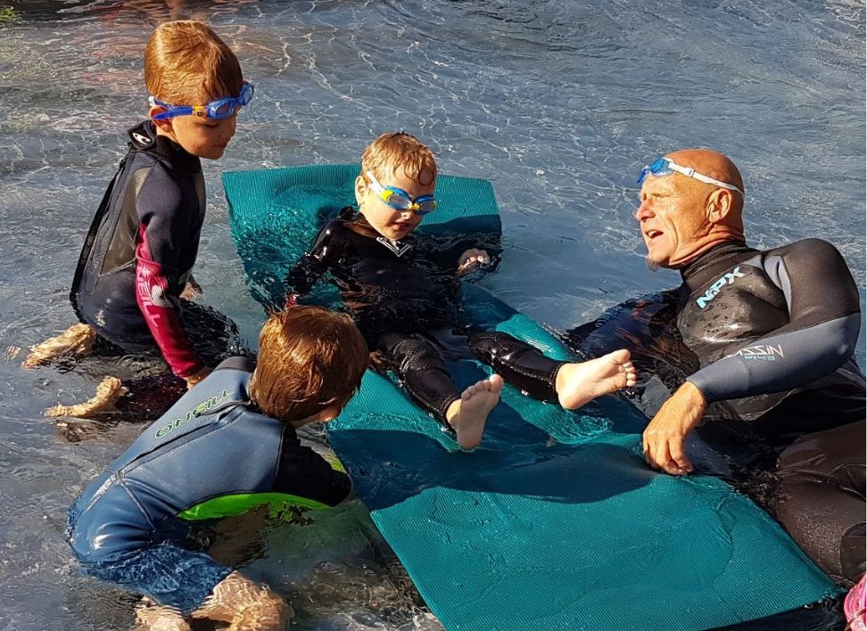 Schwimmlehrer bietet einen Schwimmkurs für Kinder