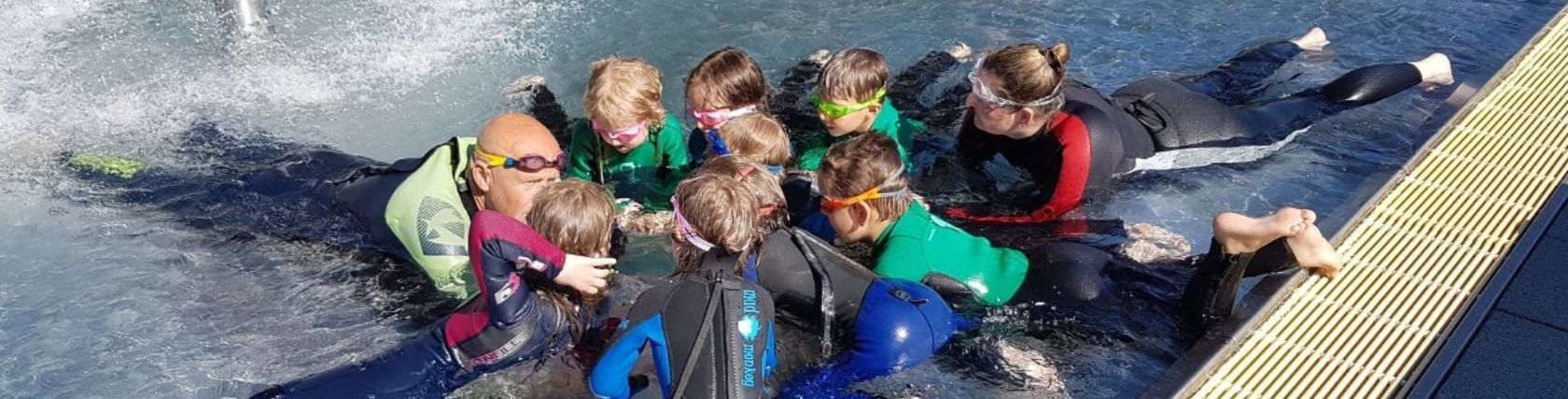 Schwimmlehrer und Kinder lernen Schwimmen